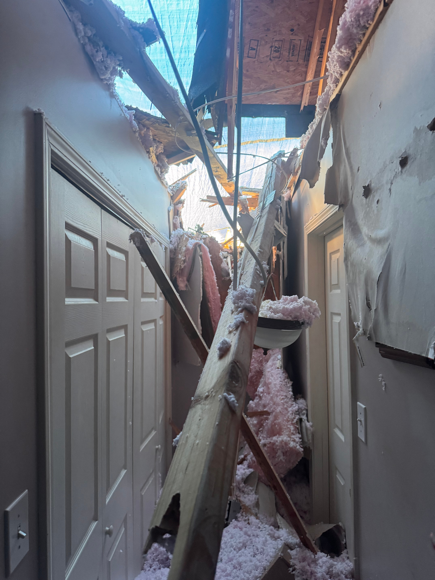 Austin hallway torn open by a lightning strike with roof and ceiling damage visible above