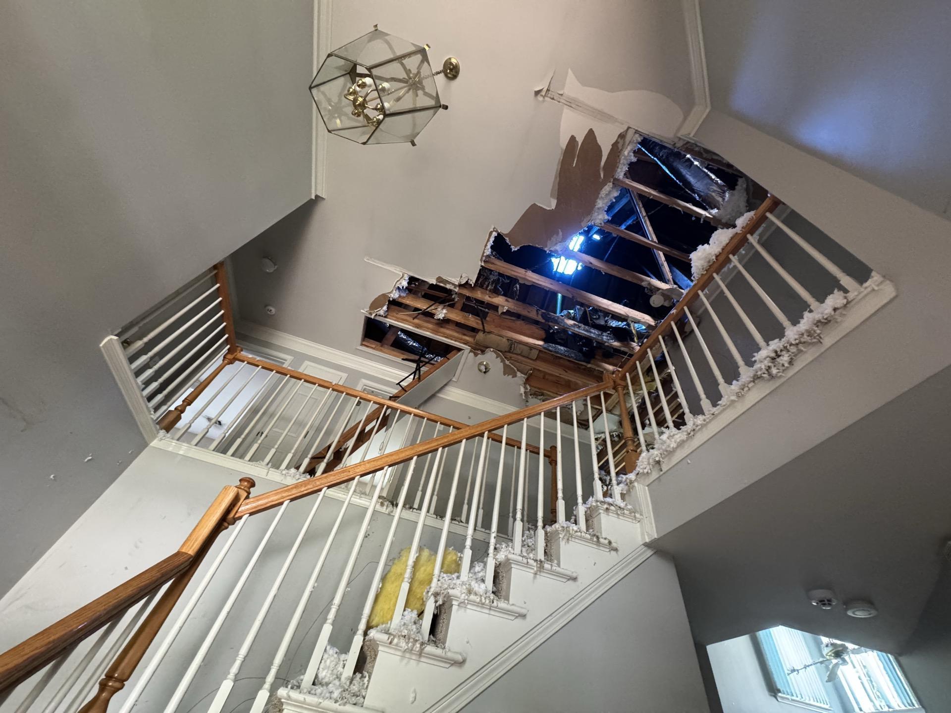 Lightning strike damage with a collapsed ceiling opening above an Austin stairwell