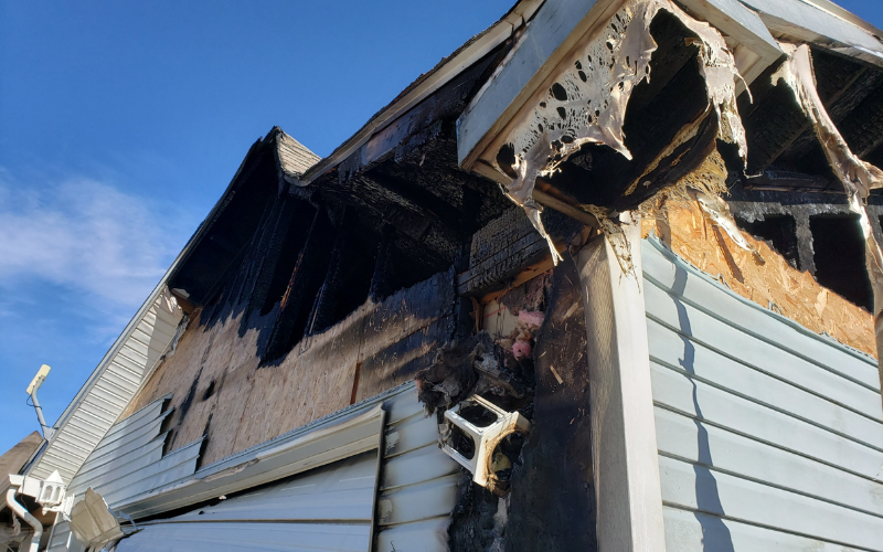 Exterior of a Austin house with fire damage to roof and siding